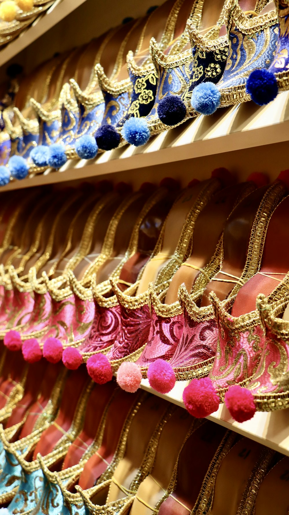 a row of different colored shoes on a shelf