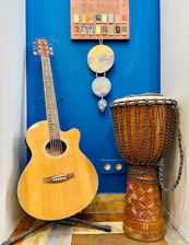 a blue wall with a guitar and a djembe