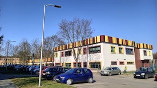 a parking lot with cars parked in front of a multi - colored building