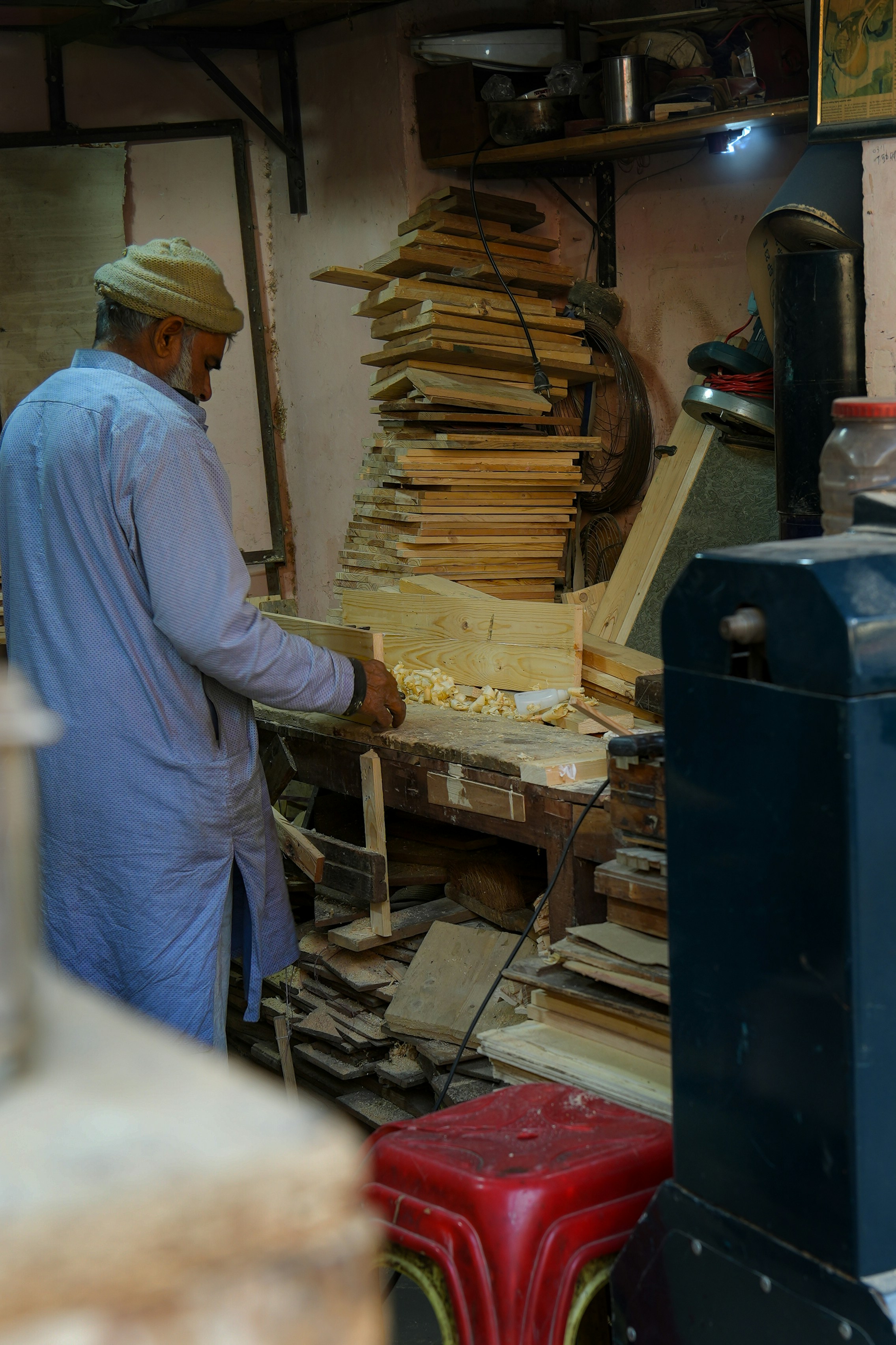 a man in a blue shirt working on a piece of wood