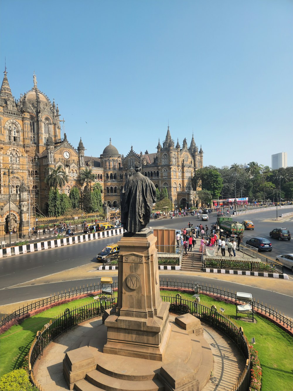 uma estátua de um homem na frente de um grande edifício