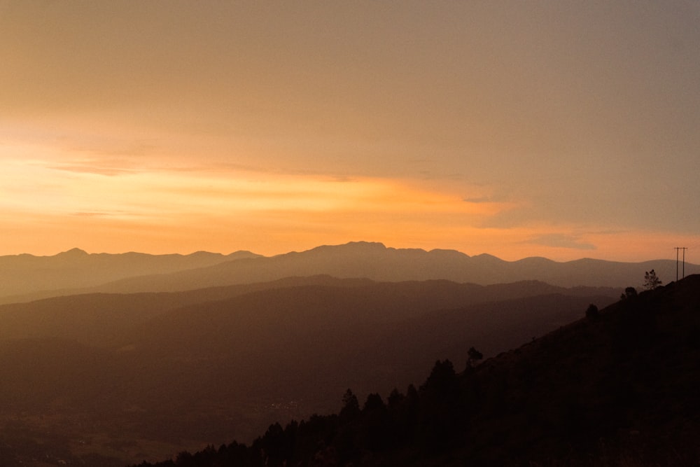 the sun is setting over a mountain range