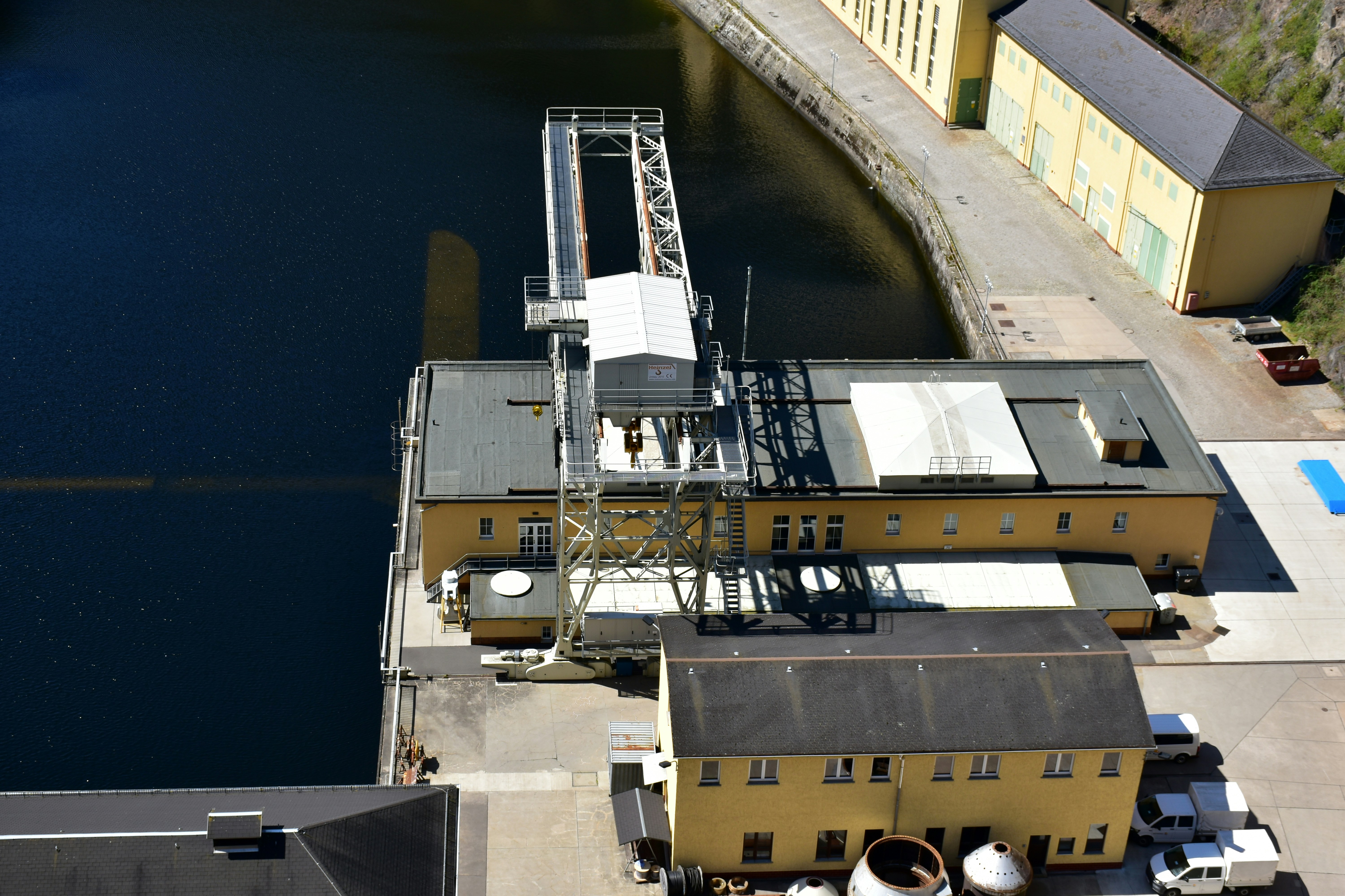 an aerial view of a building next to a body of water