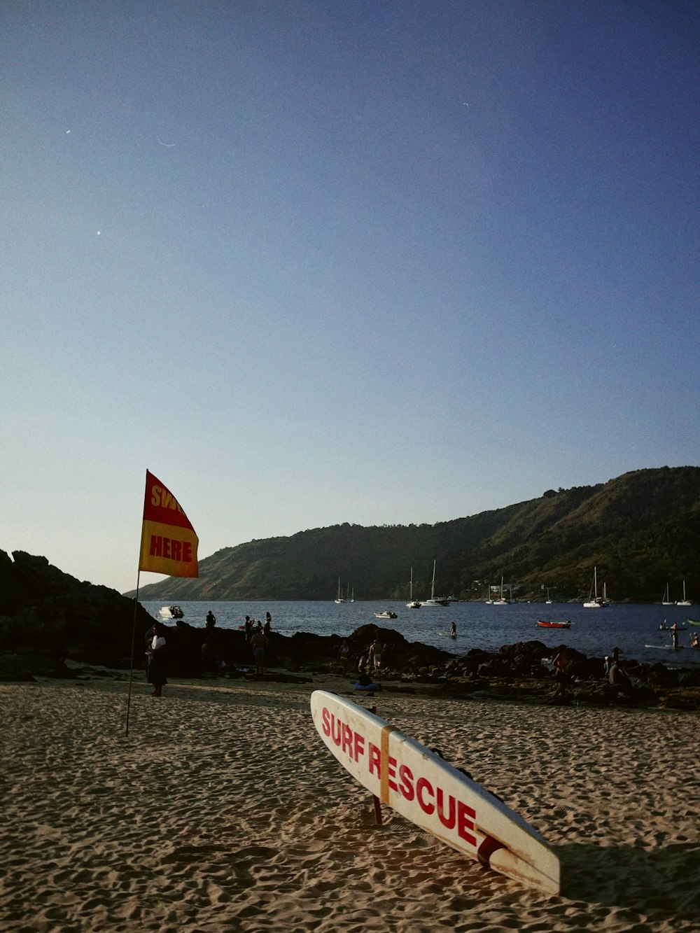 a surfboard on the beach with a flag in the background