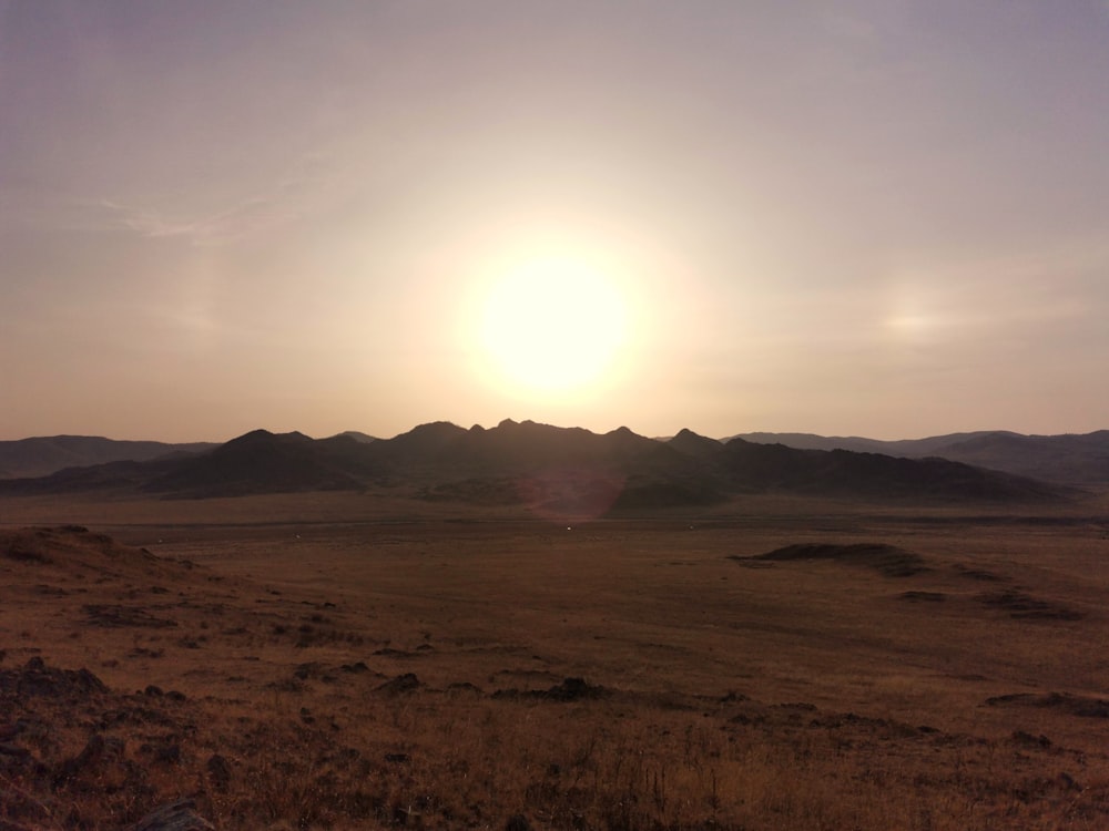 el sol se está poniendo sobre las montañas en el desierto