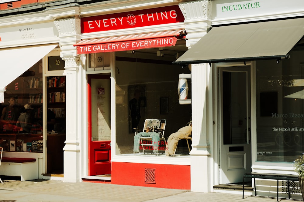 a red and white store front with a chair in the window