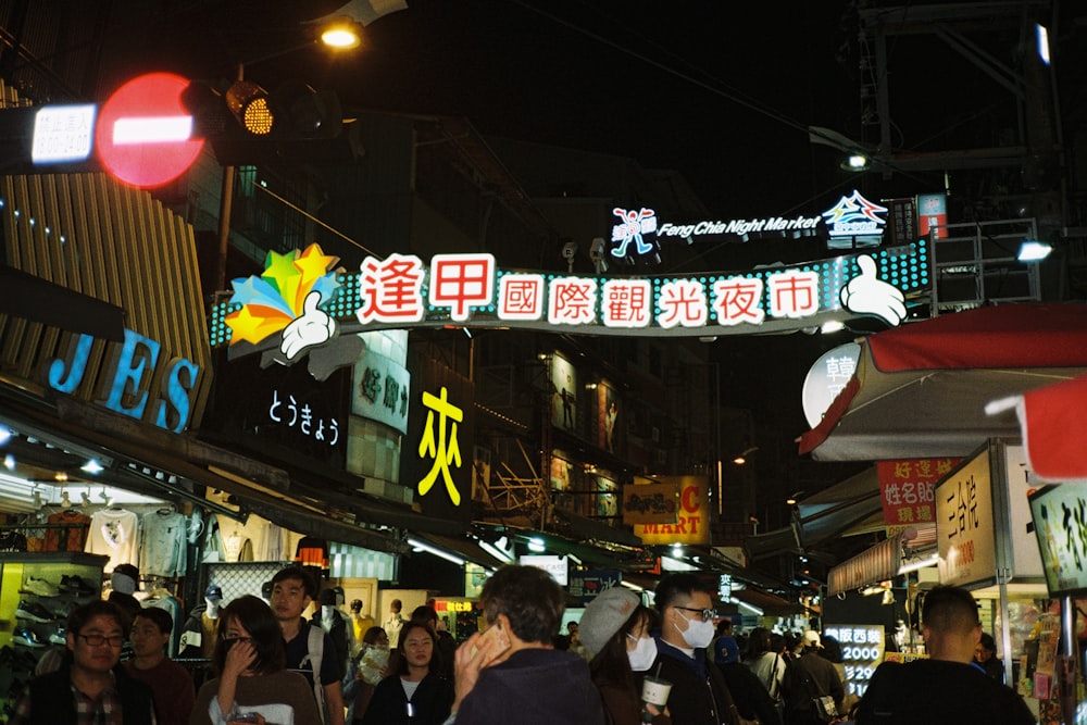 a group of people walking down a street at night