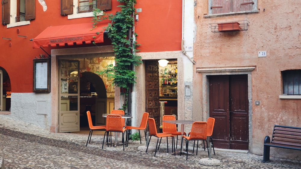 a row of orange chairs sitting in front of a building