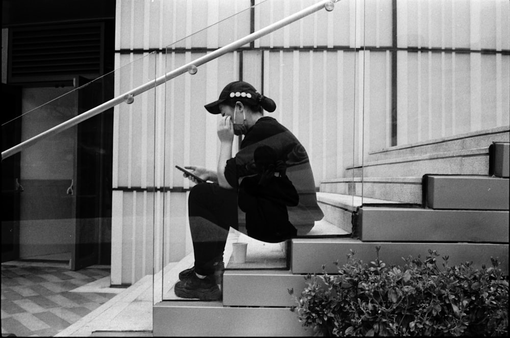 une personne assise sur un escalier à l’aide d’un téléphone cellulaire ;