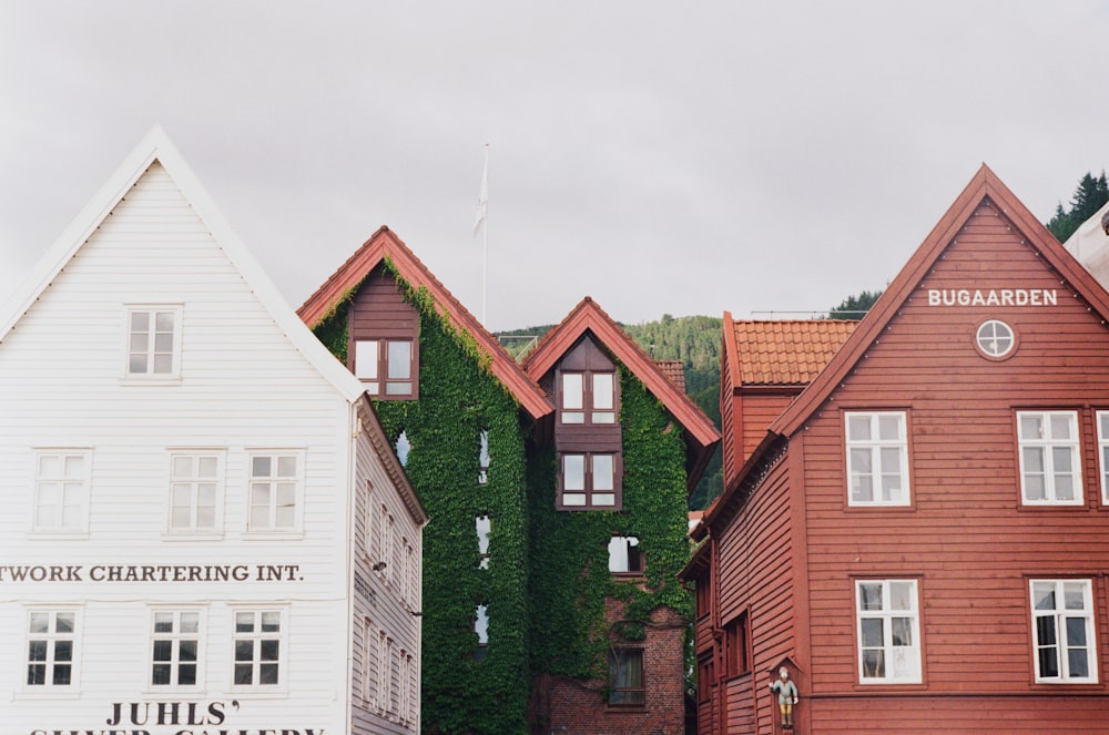 a row of wooden buildings with ivy growing up the side of them