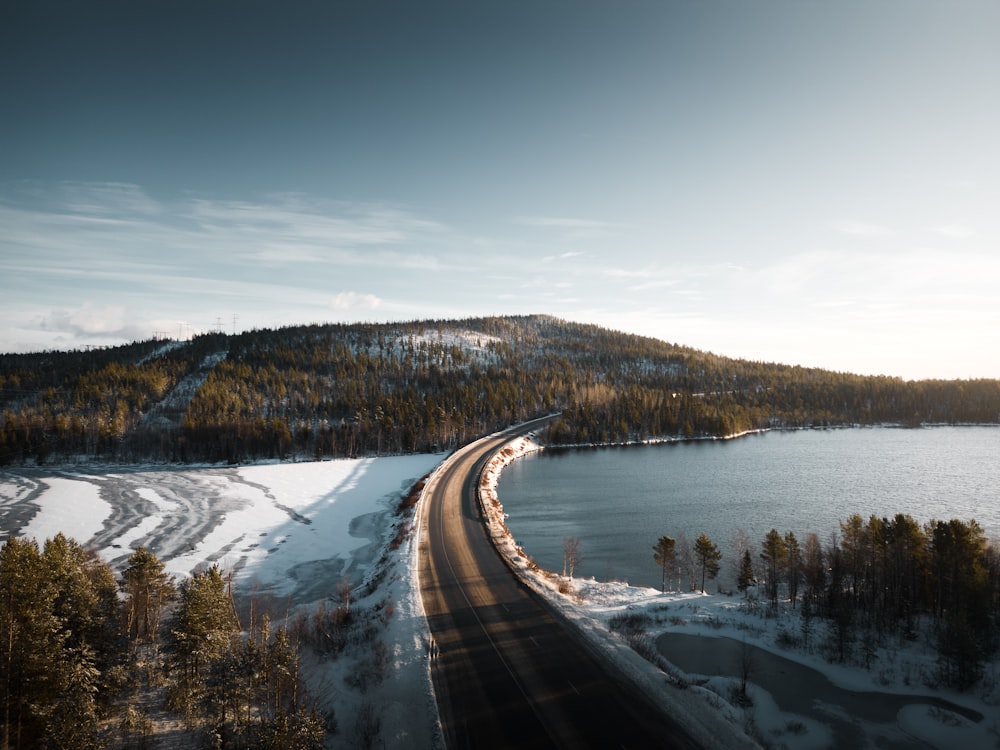 an aerial view of a road near a lake