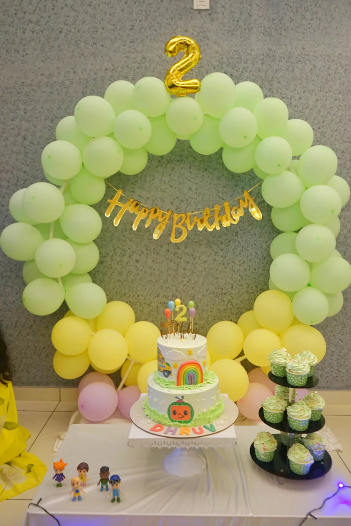 Birthday cake and cupcakes arranged on a decorated dessert table