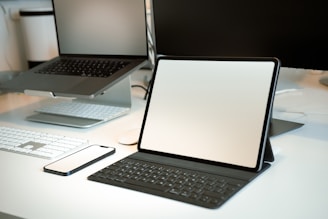 a desk with a laptop and a tablet