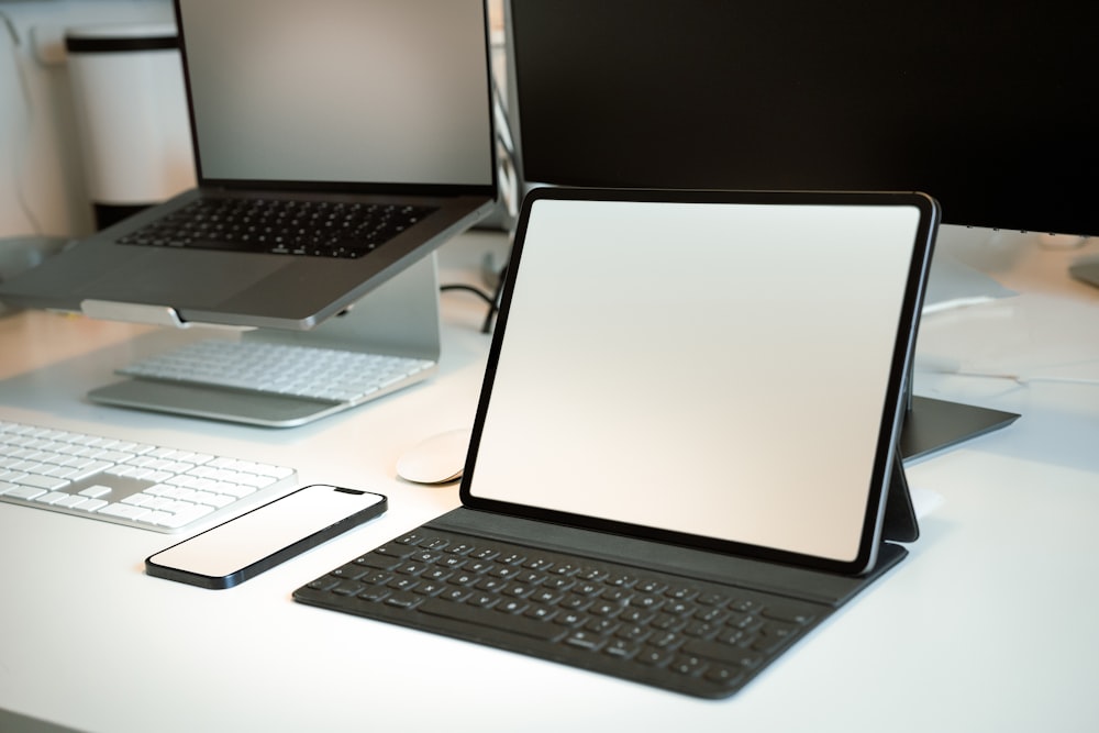 a desk with a laptop and a tablet