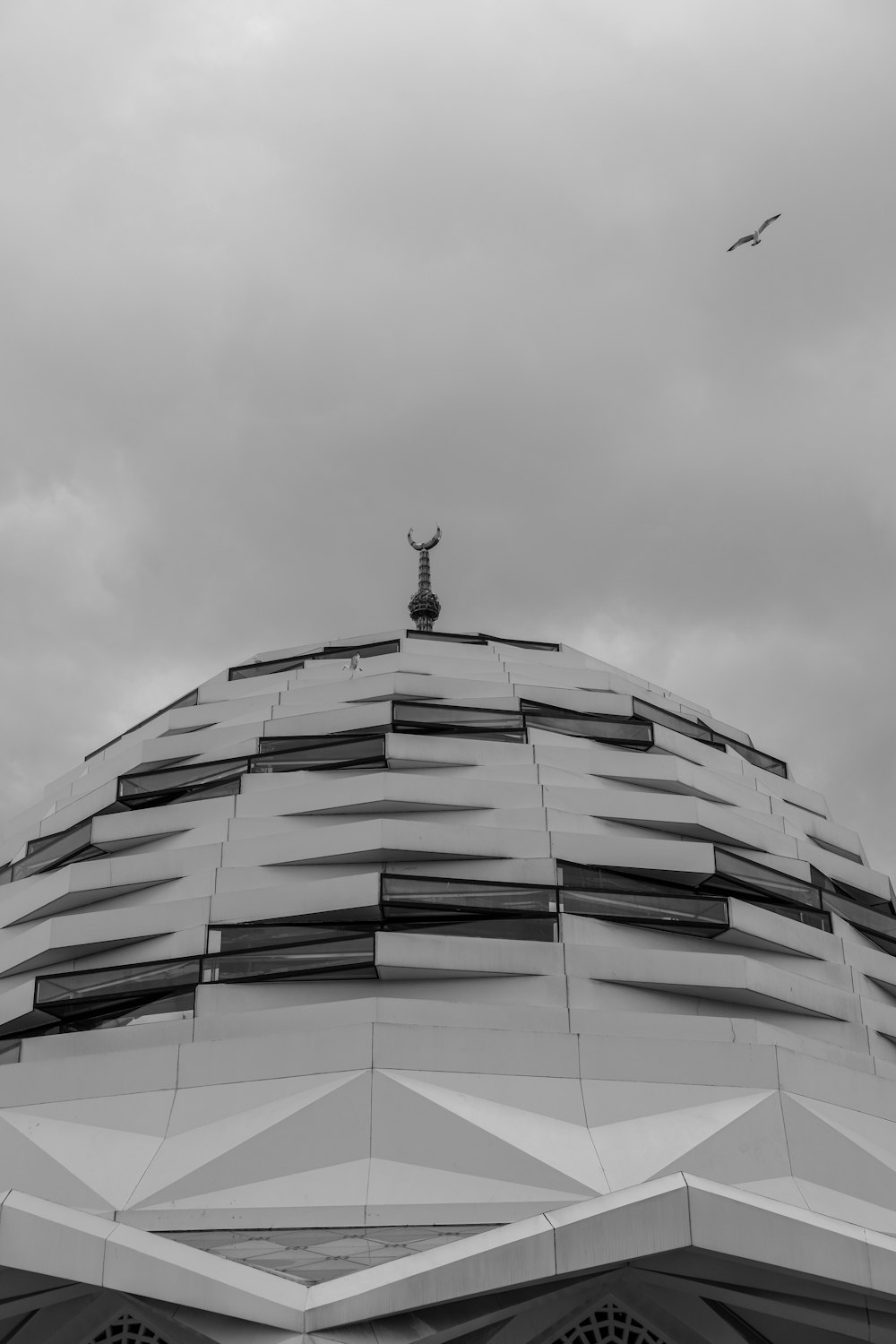 a black and white photo of a building with a statue on top