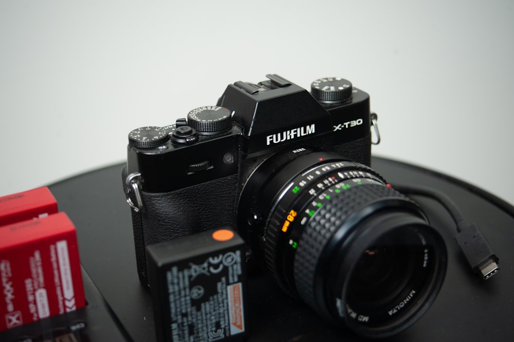 a camera sitting on top of a table next to a battery