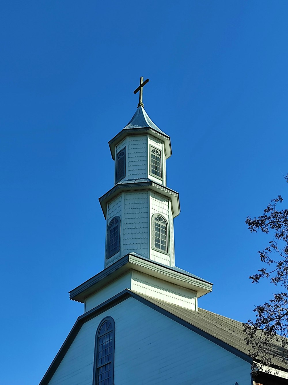 ein Kirchturm mit einem Kreuz auf der Spitze