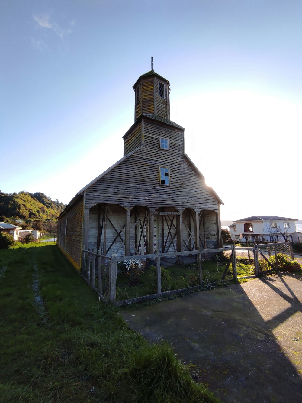 an old wooden church with a steeple and a clock tower