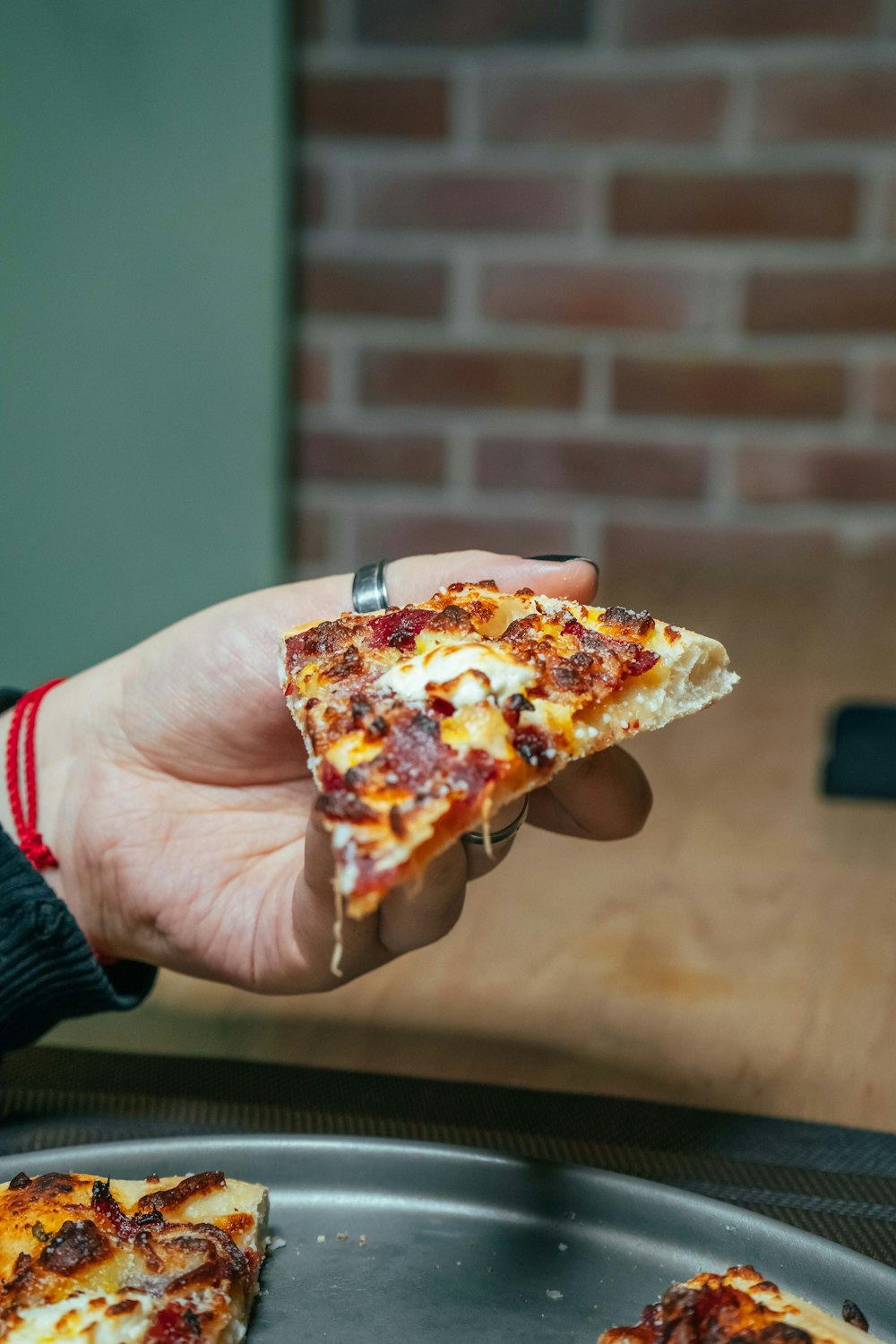 a person holding a slice of pizza in their hand
