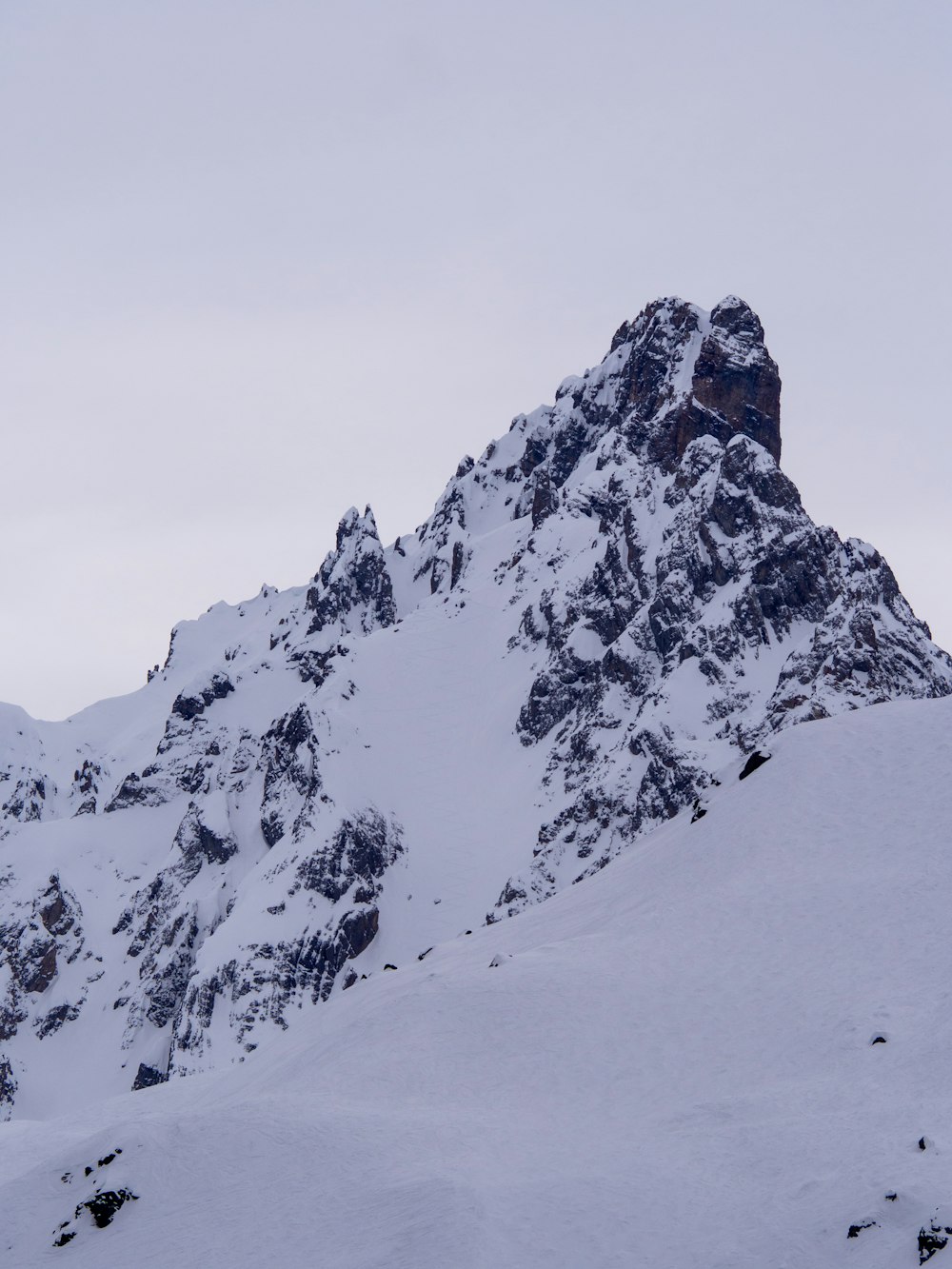 a mountain covered in snow with a sky background