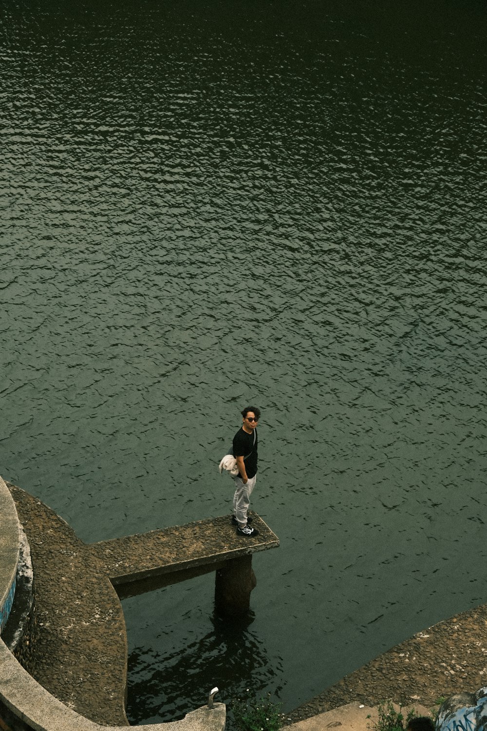 a man walking across a bridge over a body of water