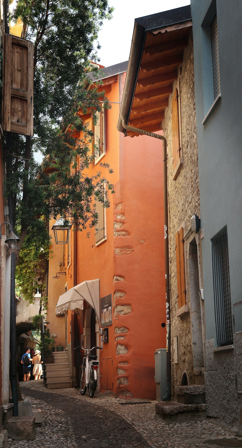 a narrow alleyway with an umbrella on the side
