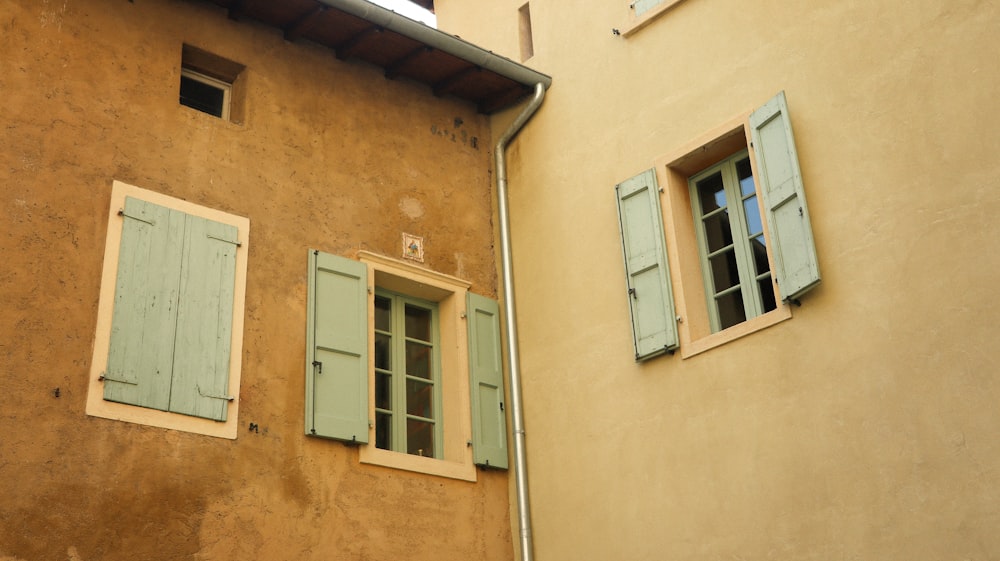 a building with two windows and shutters open