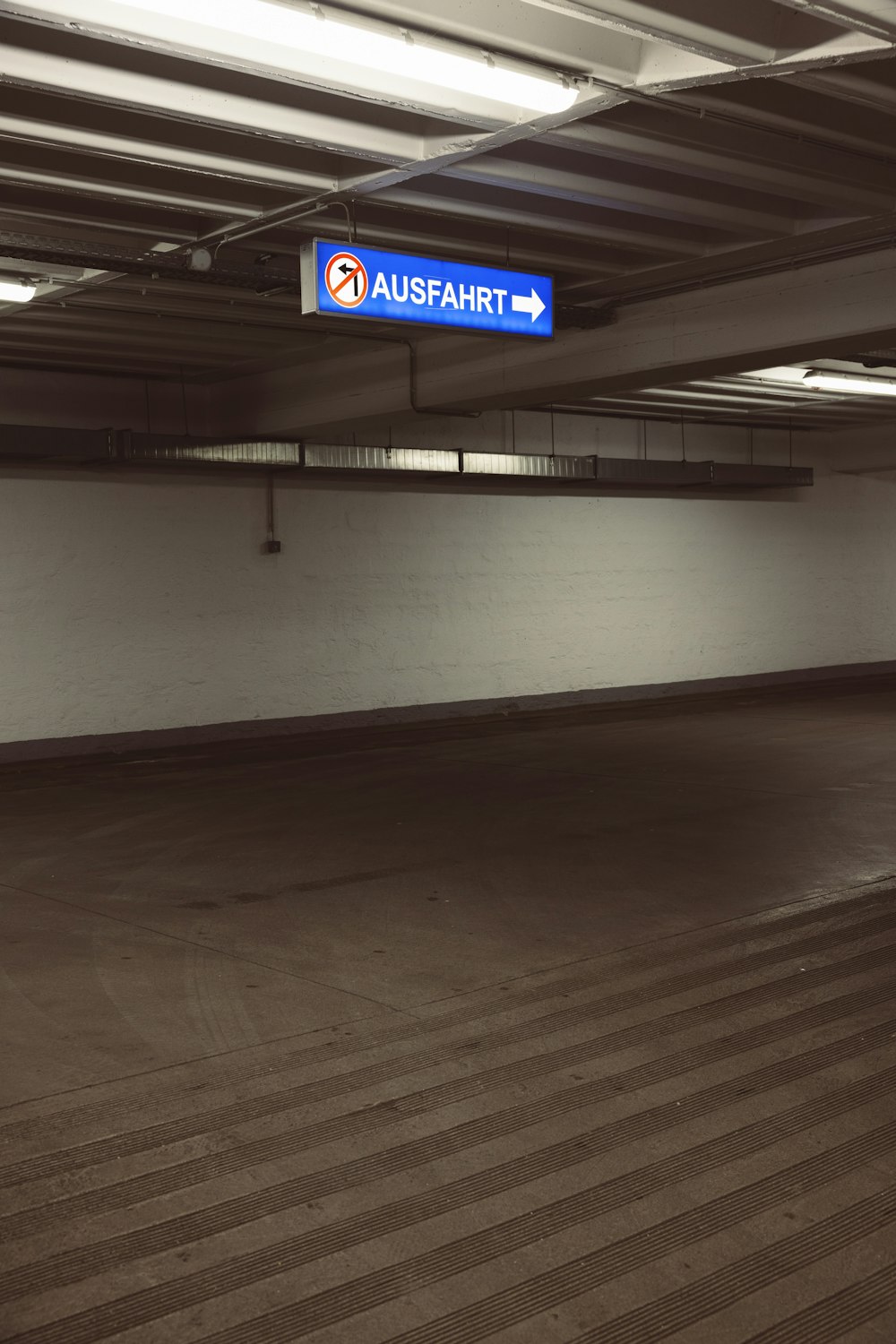 an empty parking garage with a blue sign