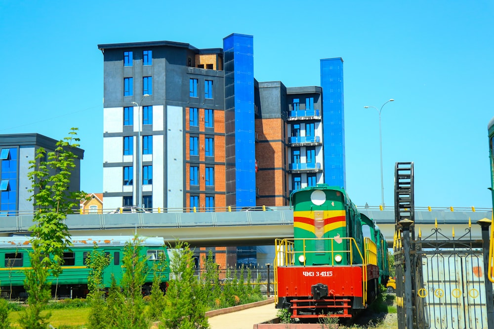 a train traveling past tall buildings on a sunny day