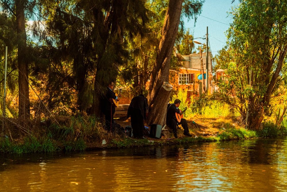 a group of people standing next to a river