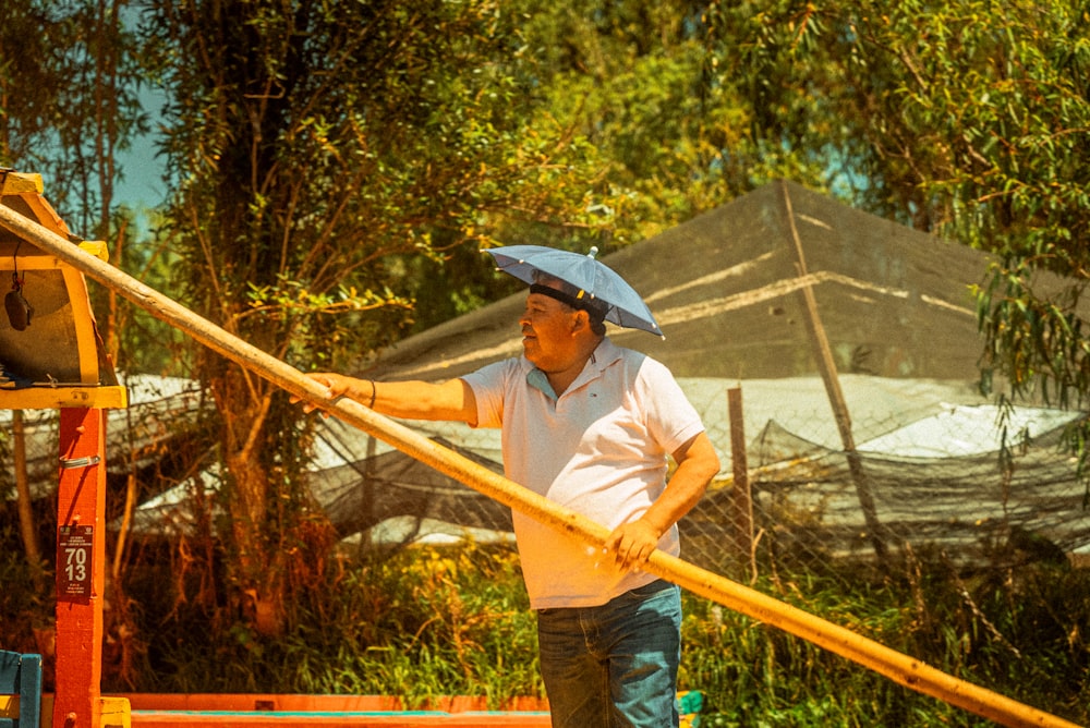 a man is holding a large wooden pole