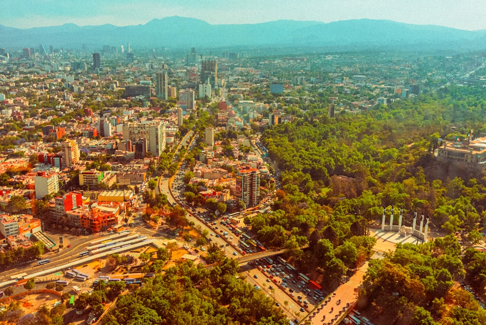 an aerial view of a city with mountains in the background