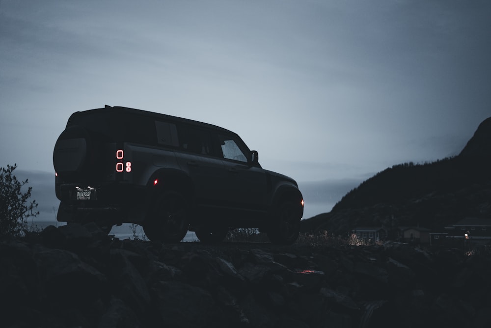 Un jeep está estacionado en una colina rocosa