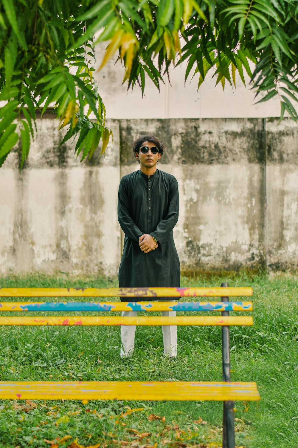 a man standing in front of a park bench