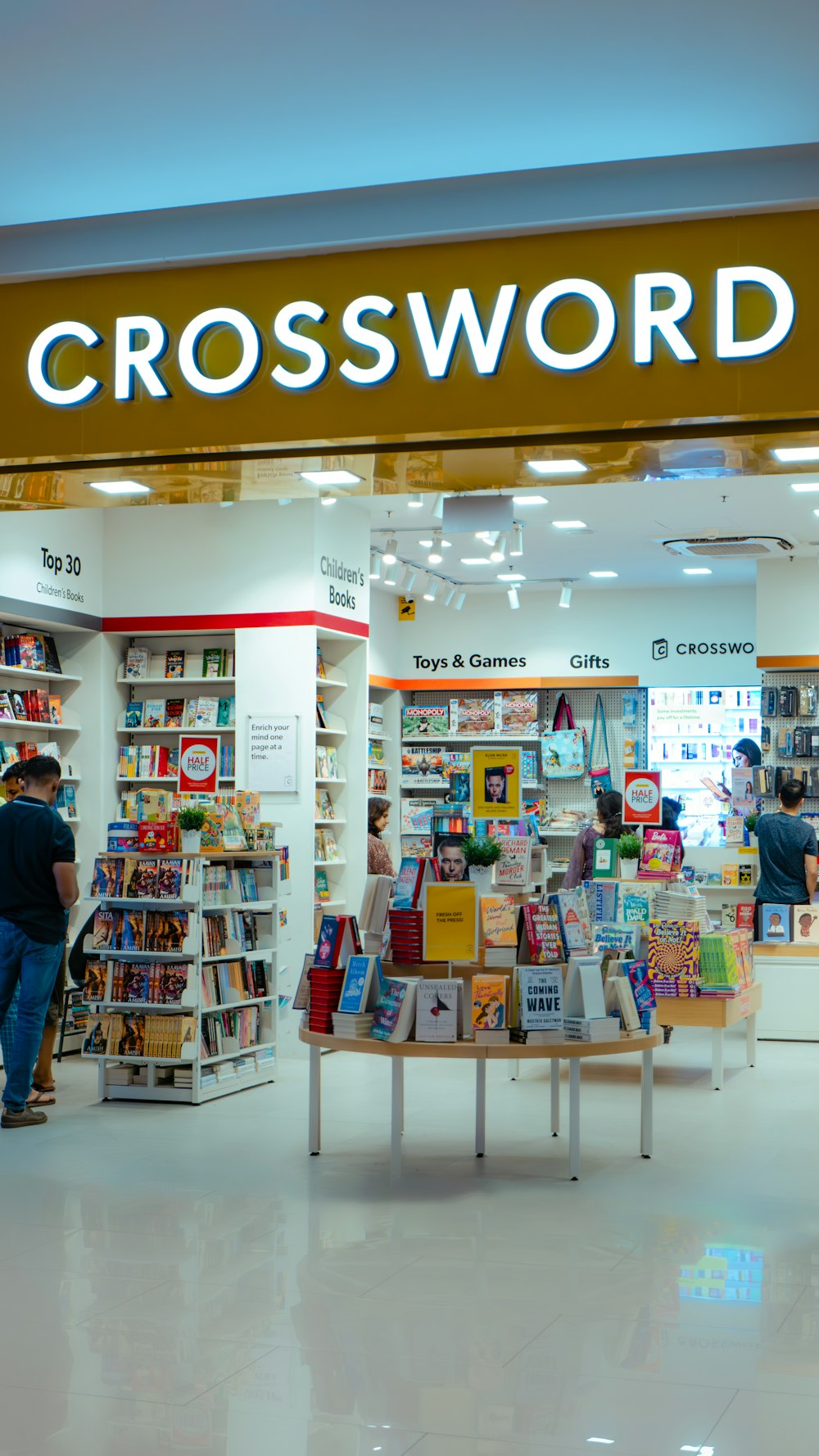 a crossword store with a man standing in front of it