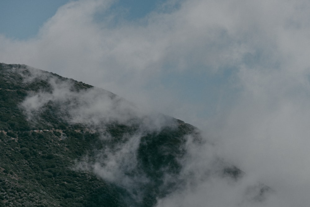 a view of a mountain covered in clouds