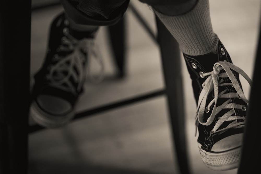 a black and white photo of a person's legs and shoes