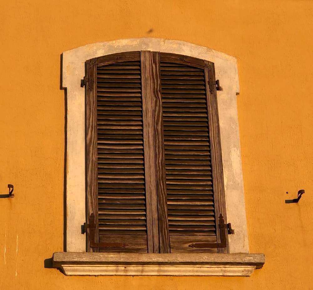 a close up of a window with wooden shutters