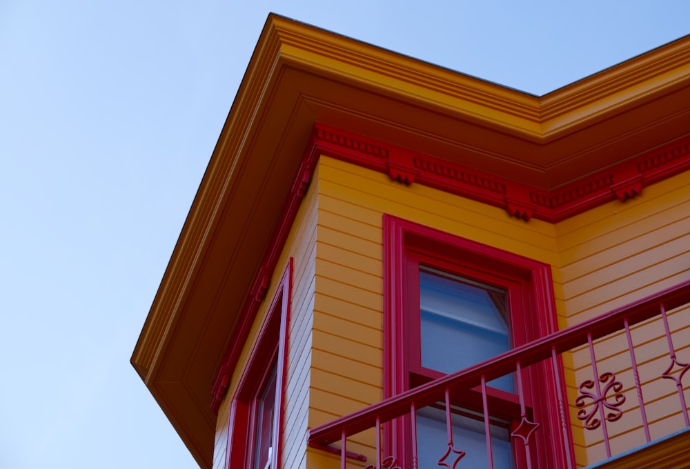 a red and yellow building with a balcony