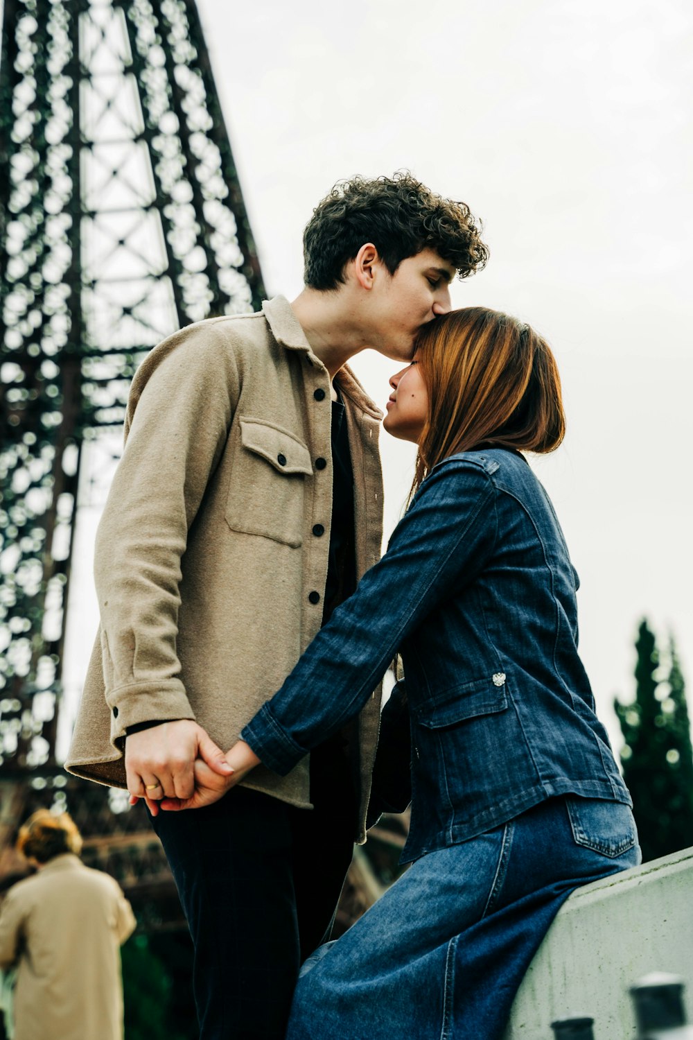 a couple kissing in front of the eiffel tower