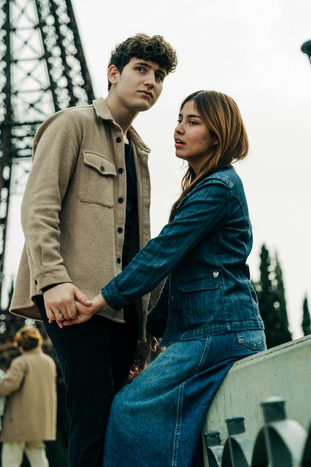 a man and a woman holding hands in front of the eiffel tower