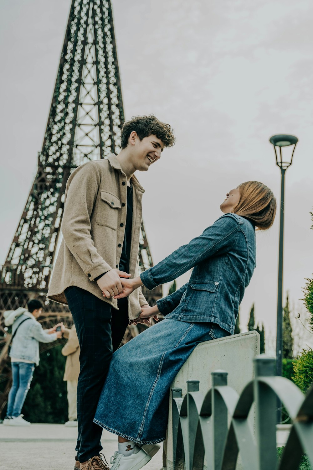 a man and a woman standing next to each other near the eiffel tower