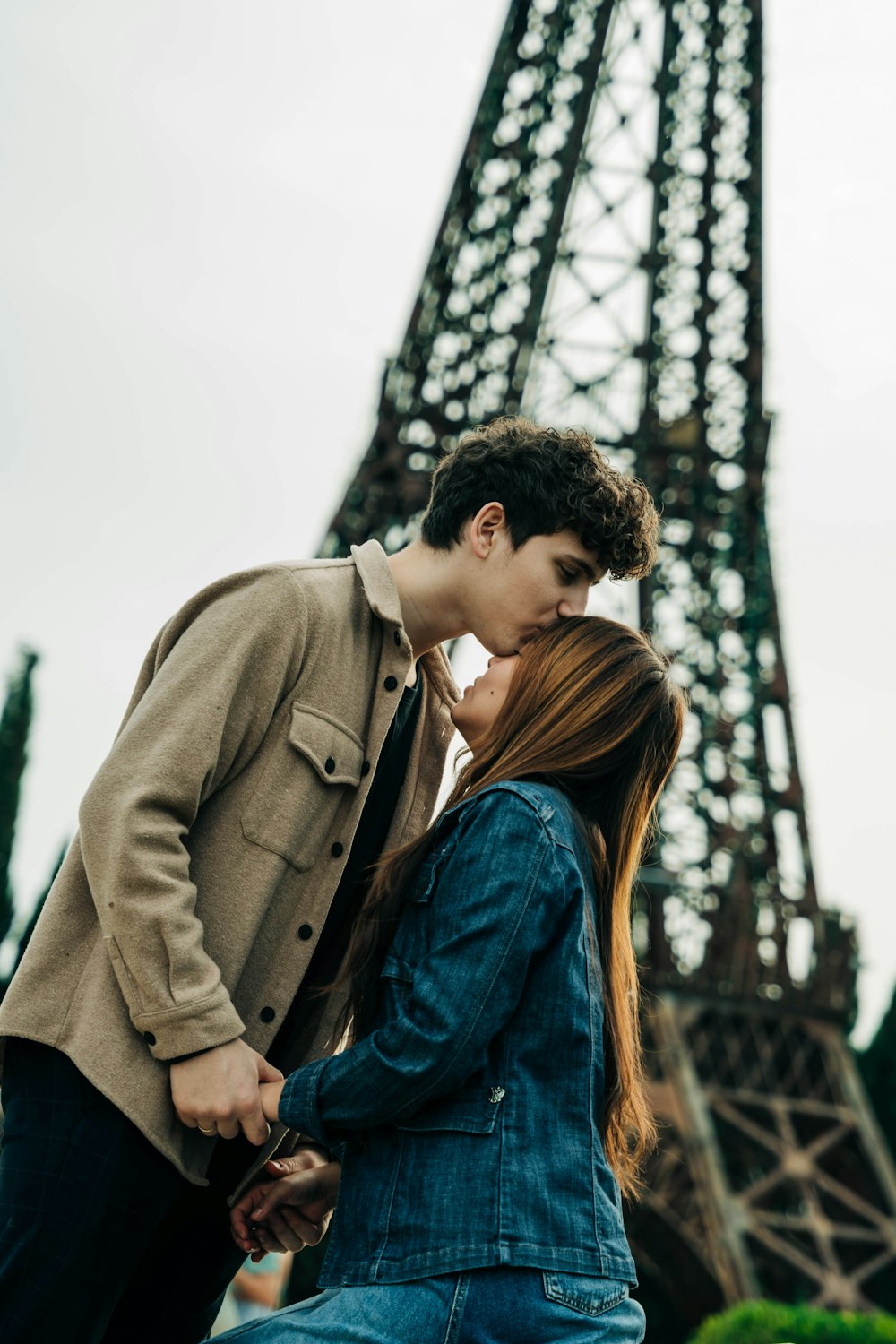 a couple kissing in front of the eiffel tower