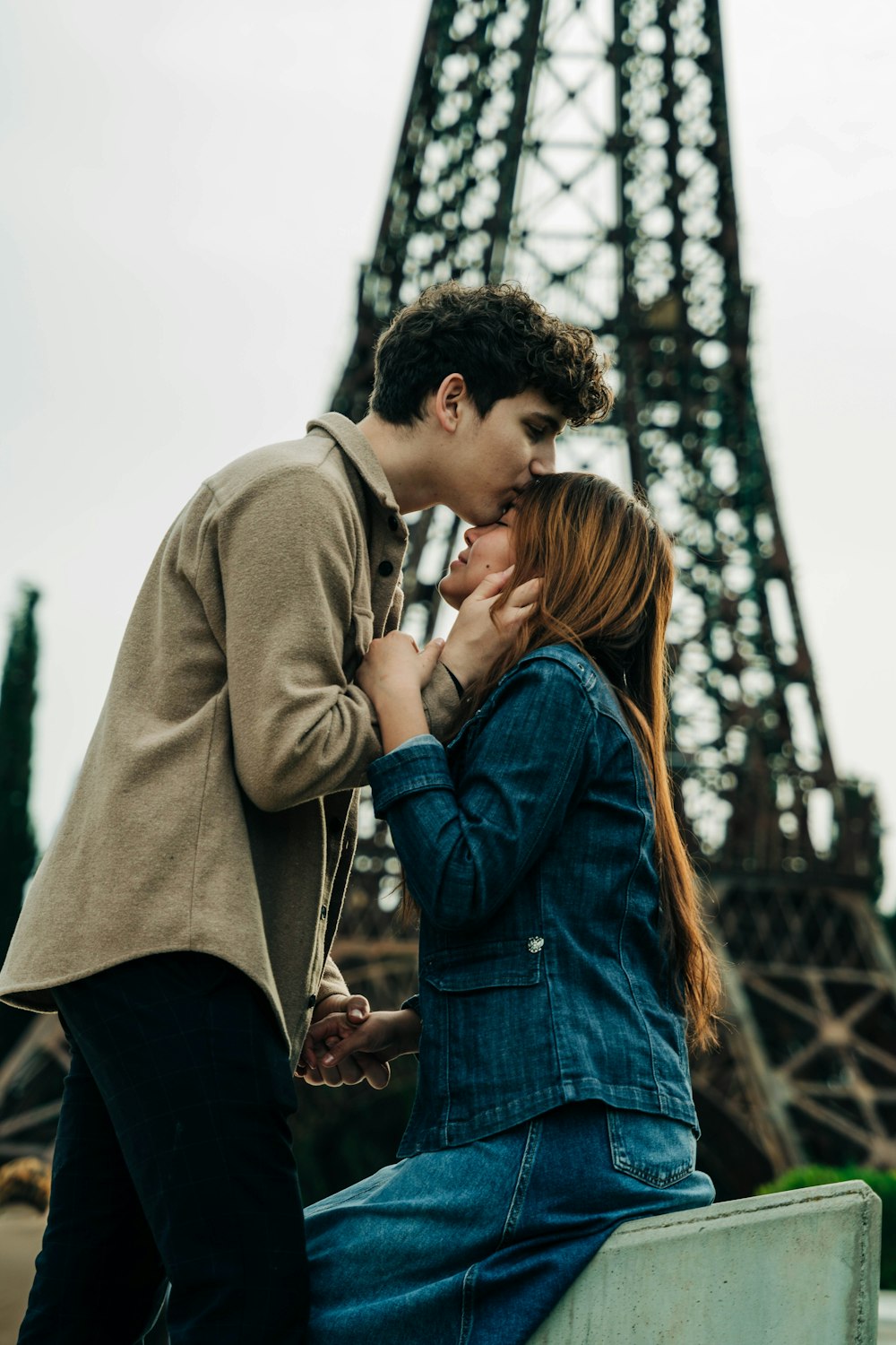 Un uomo e una donna che si baciano davanti alla Torre Eiffel