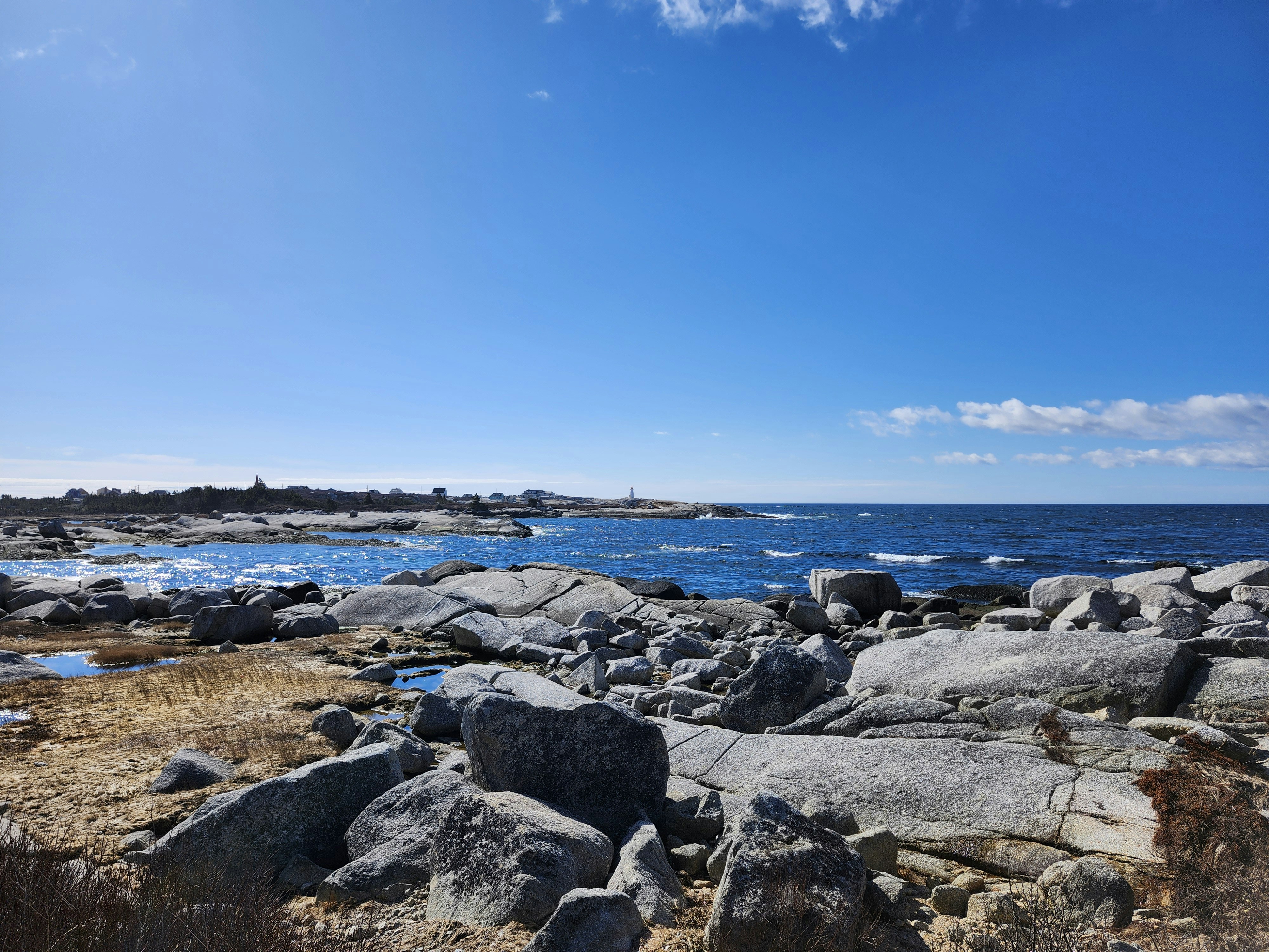 a rocky beach with a body of water in the background