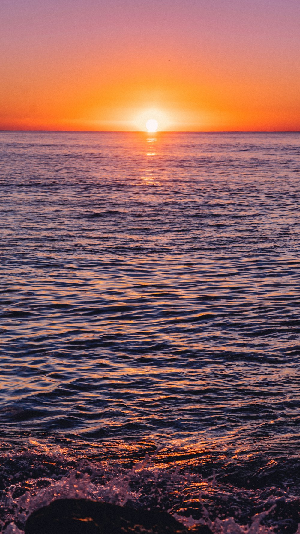 the sun is setting over the ocean on a clear day