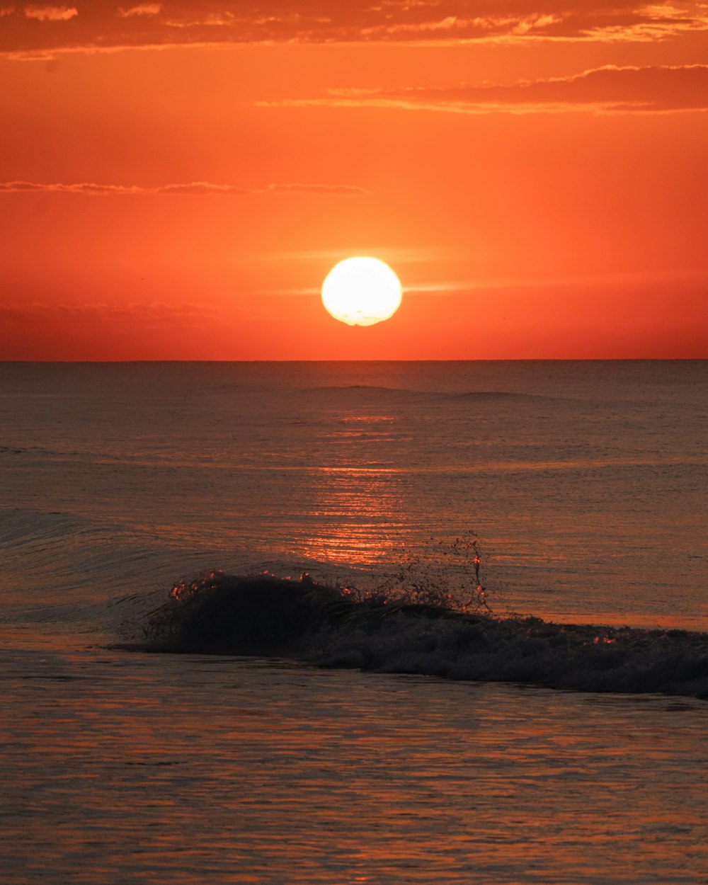 the sun is setting over the ocean with waves