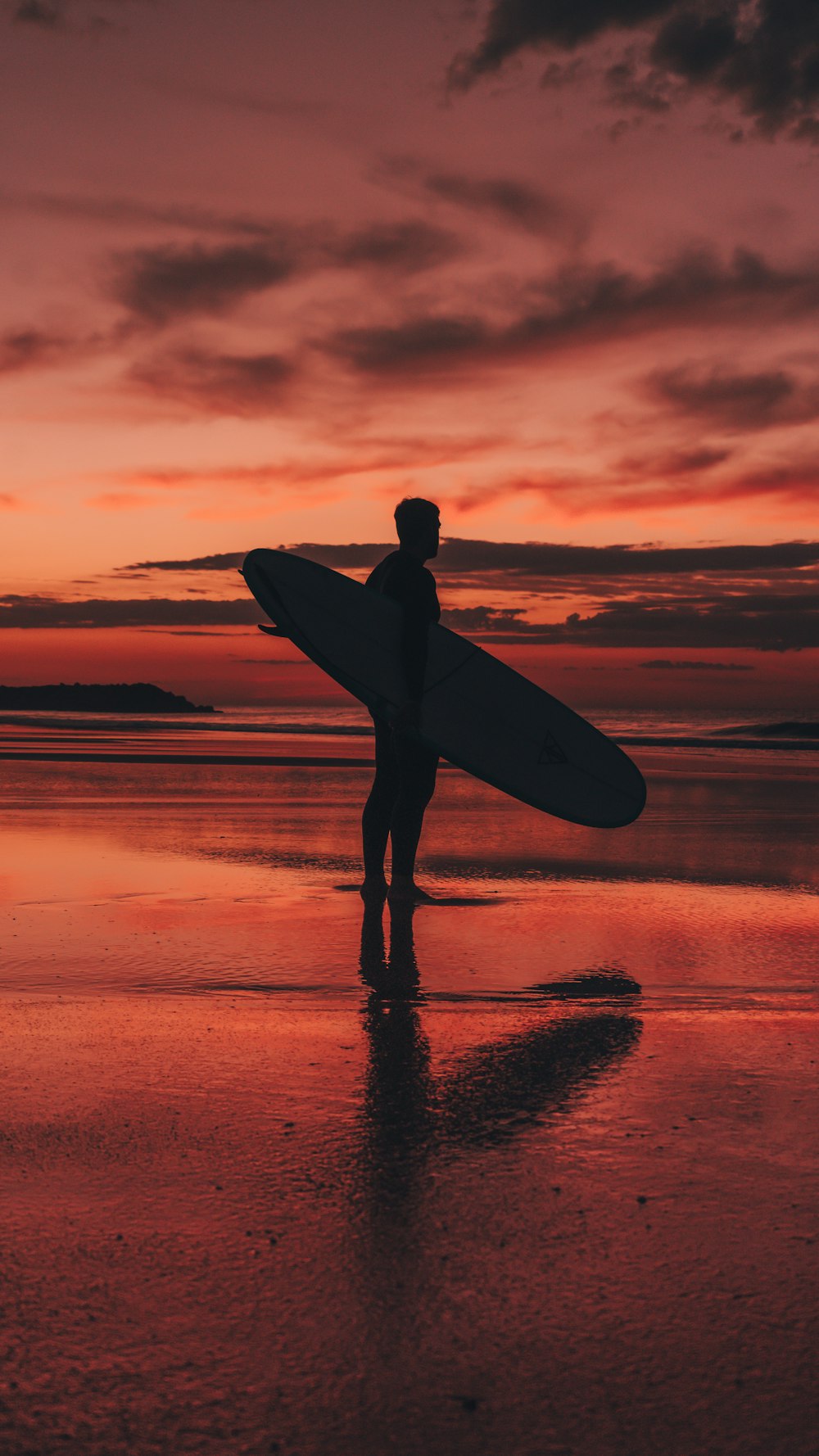 a man holding a surfboard while standing on a beach