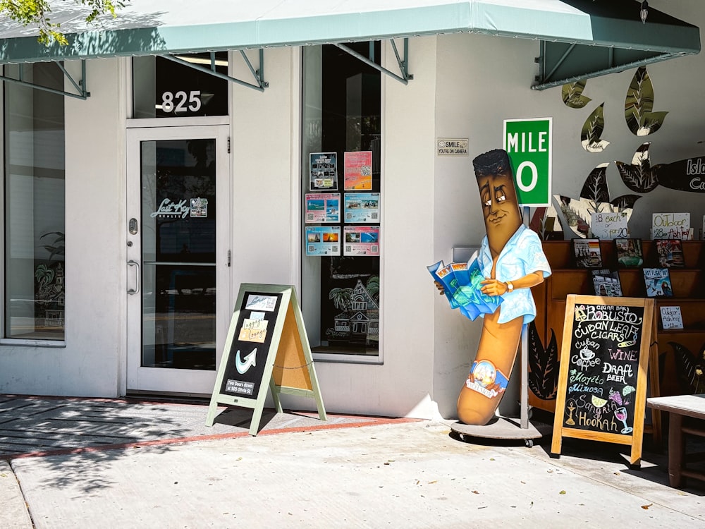 a statue of a man holding a map in front of a store