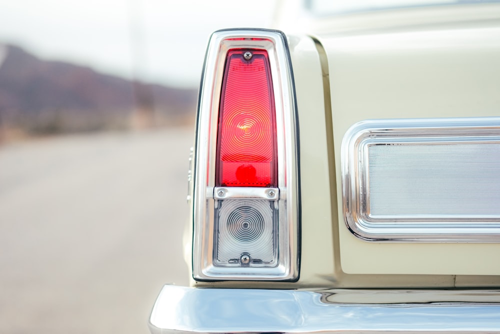 the tail light of a white car on the road